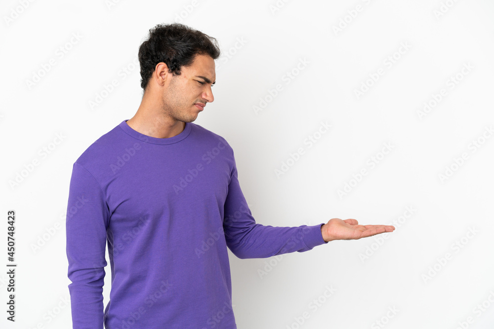 Caucasian handsome man over isolated white background holding copyspace with doubts Caucasian handsome man over isolated white background holding copyspace with doubts