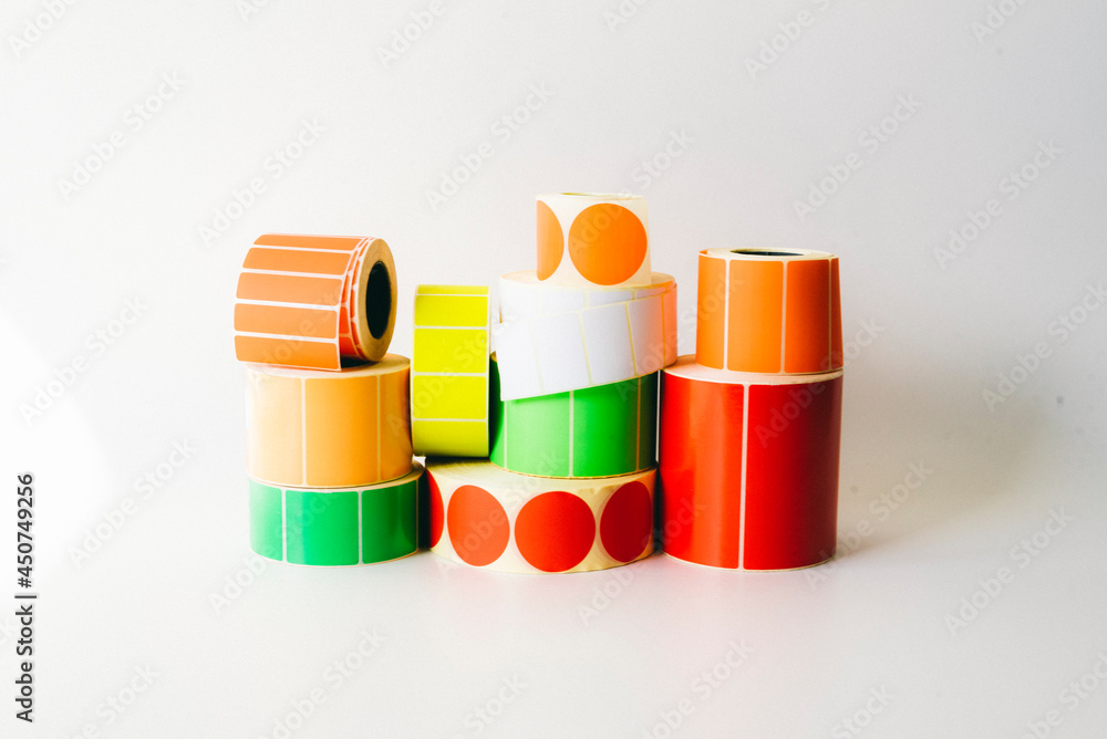 Different colored bobbins of self-adhesive stickers on a white ...