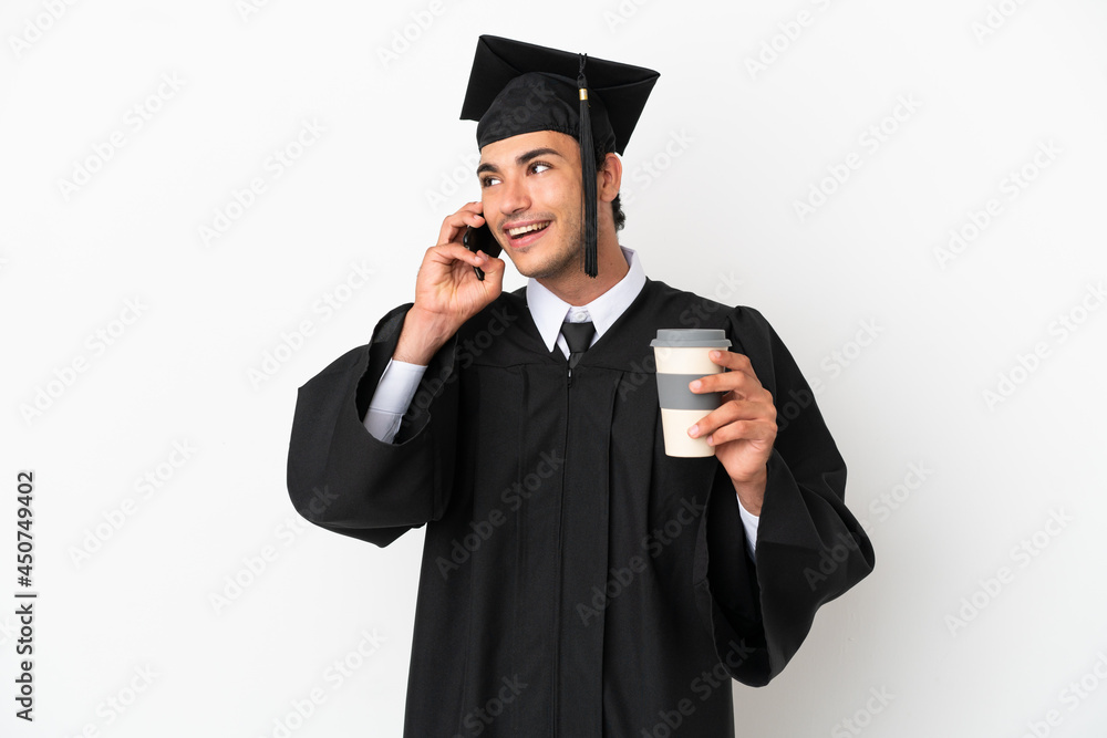 Young university graduate over isolated white background holding coffee to take away and a mobile Young university graduate over isolated white background holding coffee to take away and a mobile