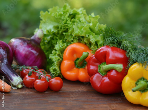 A set vegetables on a wooden background: carrots, potatoes, zucchini, paprika, cucumber, garlic, tomatoes, lettuce.Healthy food concept with vegetables and ingredients for cooking. Top view.Copy space