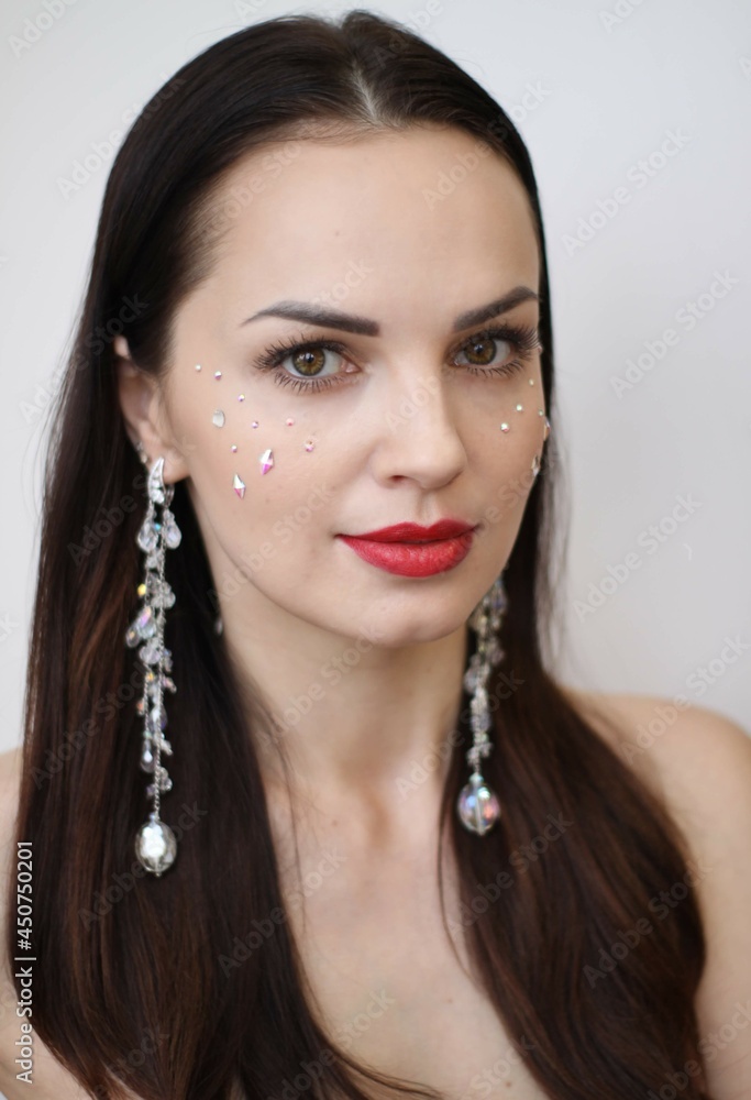 brunette girl with long massive earrings. costume jewelry