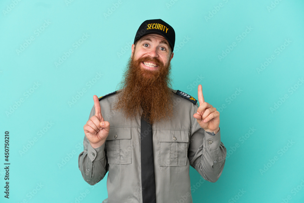 Redhead security man isolated on white background pointing up a great idea Redhead security man isolated on white background pointing up a great idea