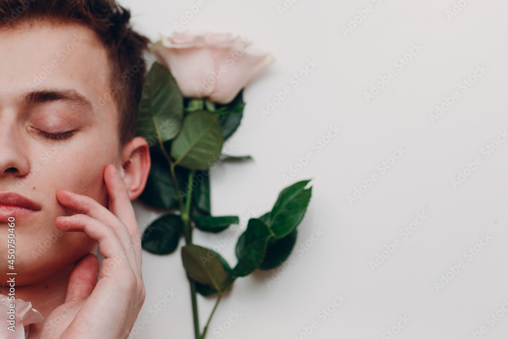 Young man model with flowers. Beauty boy portrait
