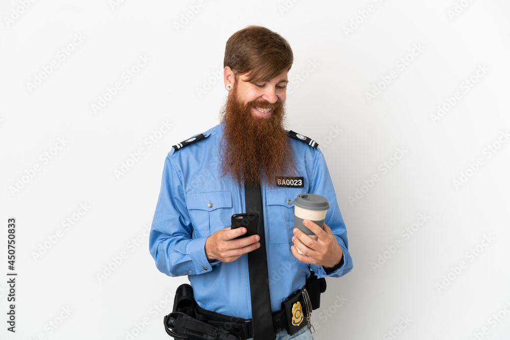 Redhead police man isolated on white background holding coffee to take away and a mobile Redhead police man isolated on white background holding coffee to take away and a mobile