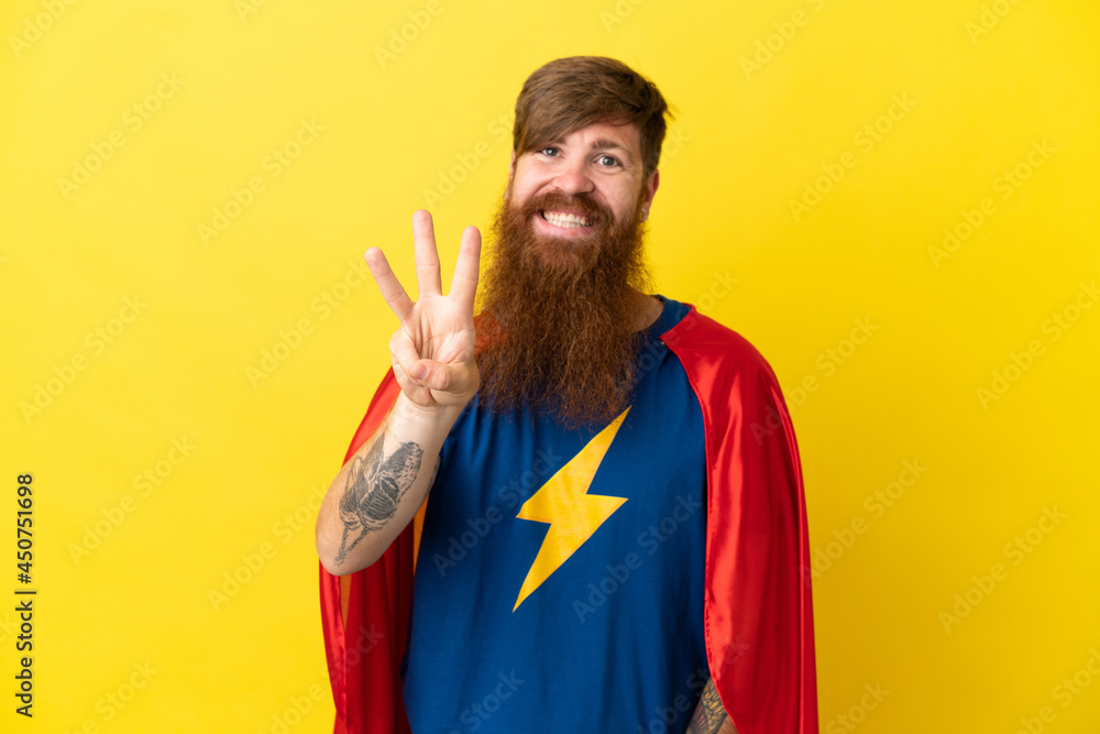 Redhead Super Hero man isolated on yellow background happy and counting three with fingers Redhead Super Hero man isolated on yellow background happy and counting three with fingers