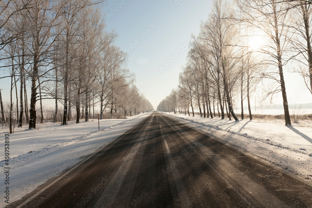 paved road covered with snow in winter