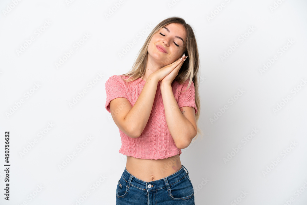 Young Romanian woman isolated on white background making sleep gesture in dorable expression Young Romanian woman isolated on white background making sleep gesture in dorable expression