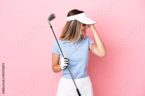 Young golfer player woman isolated on pink background laughing