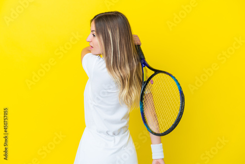 Young Romanian woman isolated on yellow background playing tennis © luismolinero