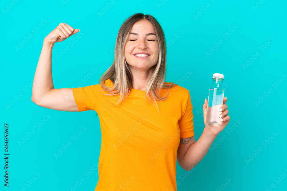 Young Romanian woman with a bottle of water isolated on blue background doing strong gesture Young Romanian woman with a bottle of water isolated on blue background doing strong gesture
