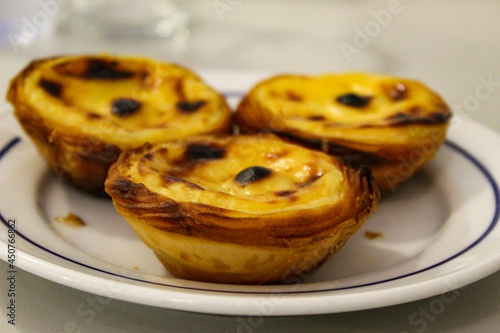 Typical Portuguese custard pies, Pastel de Nata or Pastel de Belem. A close-up of traditional Portuguese custard pastries in traditionl caffe - restorant. Pastel de nata. Pastéis de Belém.