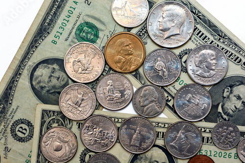 Background of old American dollars banknotes of different values 1dollar bill, 2 dollars and 5 dollars with American coins of different values 1 cent, 25, 50 cents and 1 US dollar coins isolated  photo