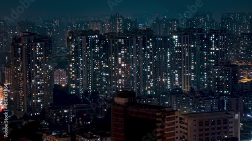 Night city apartments time lapse loop. Chinese crowded city with lights turning on and off at midnight. Fast paced modern Asian night-scape time lapse in urban metropolis.