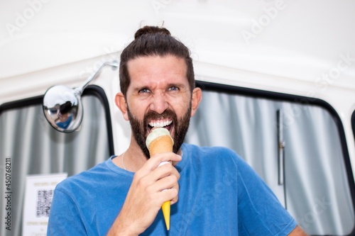 Young model man eating ice cream with rage face and retro background.