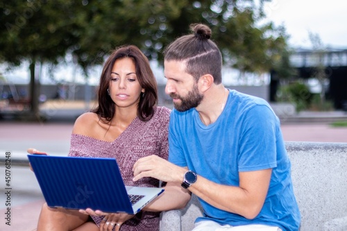 Young friends traveling monitoring their stock prices remotely with laptop.
