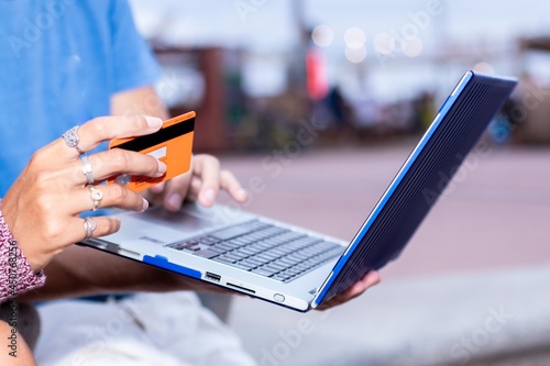 Two friends searching in internet something to buy with credit card.