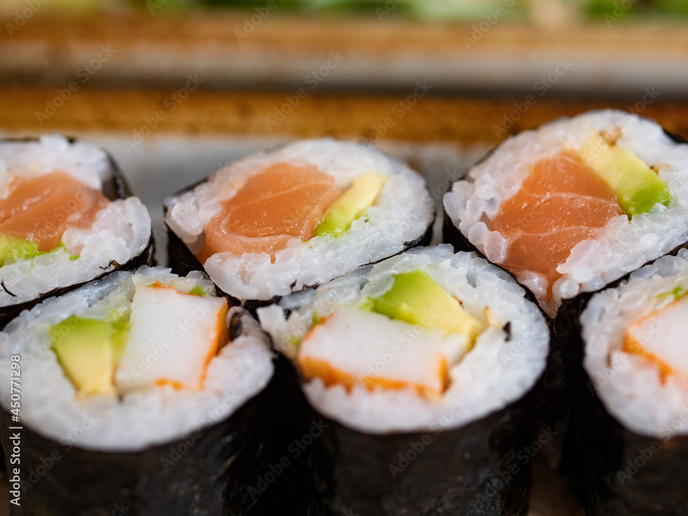 Close-up japanese sushi Maki with salmon and avocado. Healthy sea food. Close-up japanese sushi Maki with salmon and avocado. Healthy sea food.