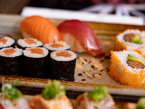Japanese sushi Hoso-Maki. Two Nigiri with salmon and tuna in the background. Healthy sea food.