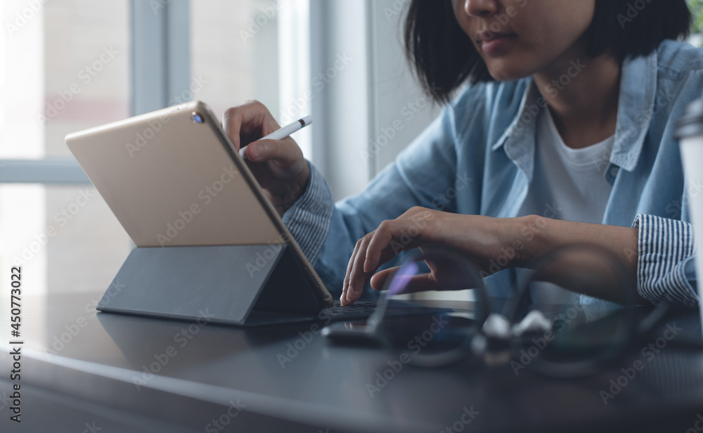 Casual business woman working on digital tablet and laptop computer at home office Casual business woman working on digital tablet and laptop computer at home office