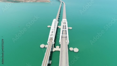 Aerial view of the crimean Bridge across the Kerch Strait. Shot. Amazing long bending bridge above calm turquoise sea. photo