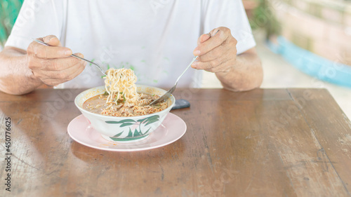 Asian man eating instant noodles