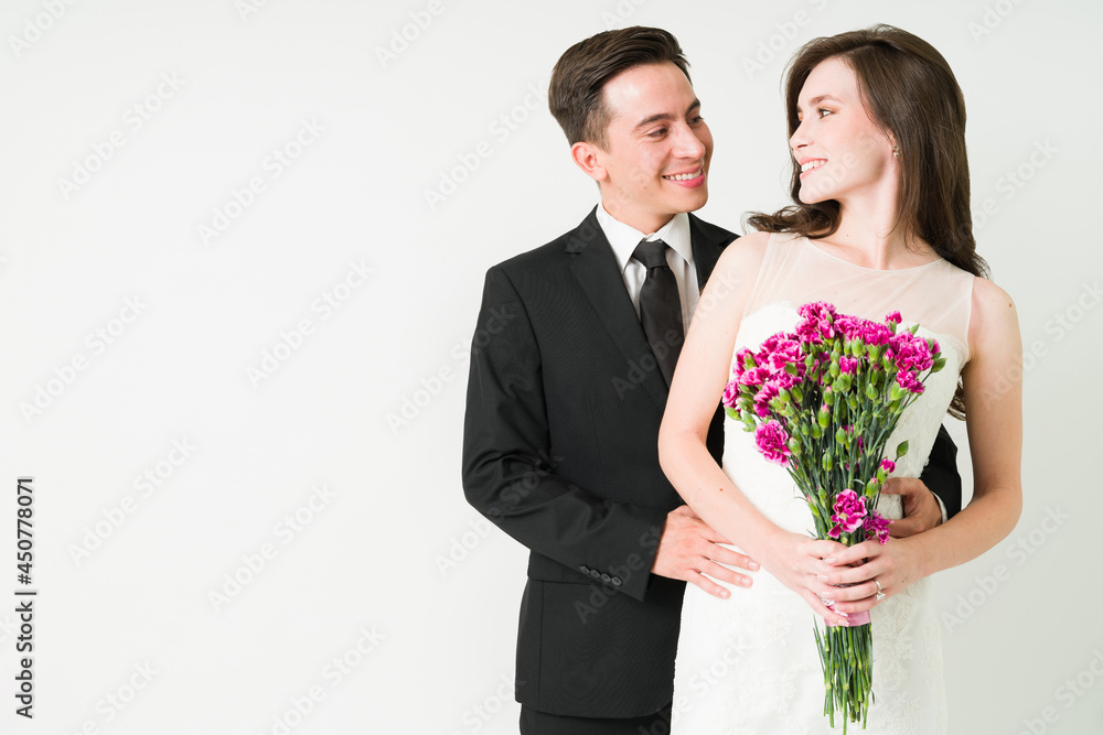 Bride and groom posing against a white background Bride and groom posing against a white background