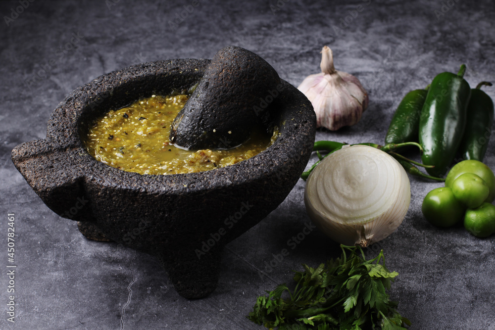 Salsa verde mexicana en molcajete. Chiles verdes, ajo, tomate verde