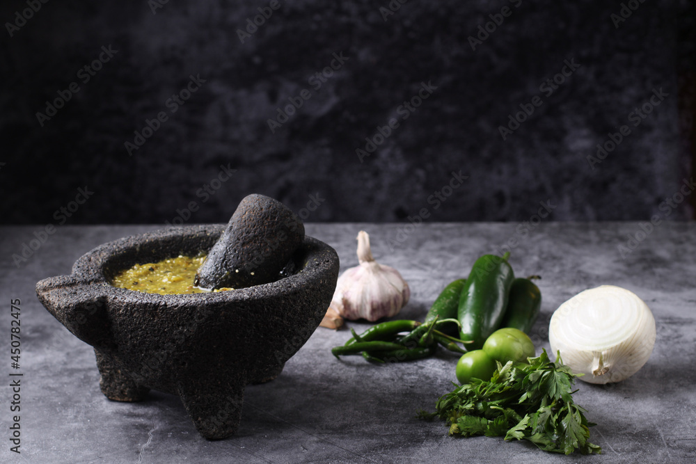 Salsa verde mexicana en molcajete. Chiles verdes, ajo, tomate verde