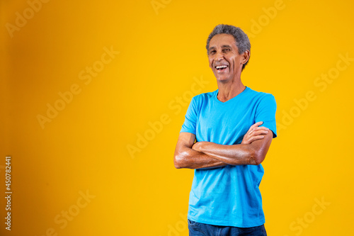 Portrait of afro elderly man with arms crossed smiling at the camera. photo