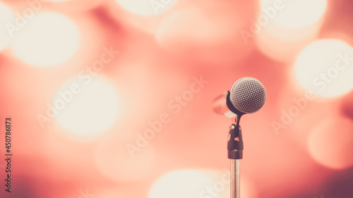 Microphone Public speaking background, Close-up the microphone on stand for speaker speech presentation stage performance with blur and bokeh light background.