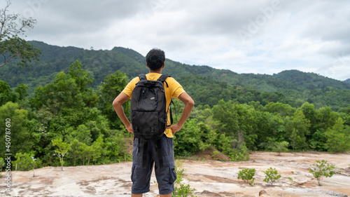Young traveler man with backpack standing relax against landscape scenery mountain peak in phuket thailand