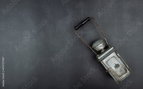 Old oil lamp on gray vintage texture.