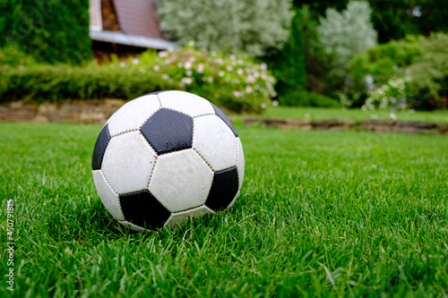 Close-up view of football ball on green grass lawn