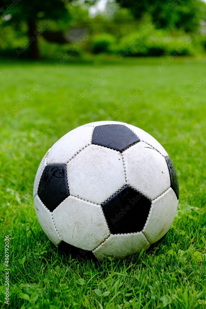 Close-up view of football ball on green grass lawn