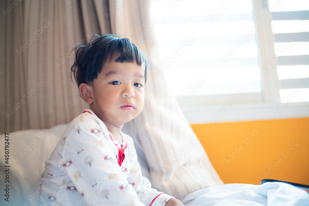 Peppy young boy in pajamas waking up in the morning and stretching Peppy young boy in pajamas waking up in the morning and stretching