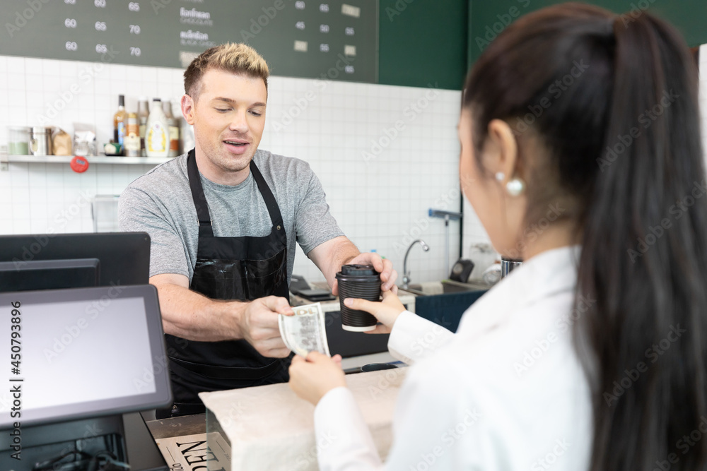 Obraz premium male barista giving a cup of coffee and getting cash from customer in cafe or coffee shop