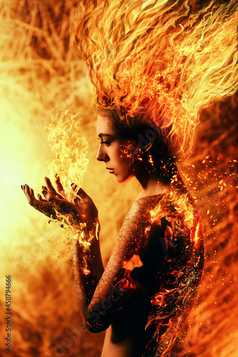 Foto Young woman with burning hair holds flames in her hands