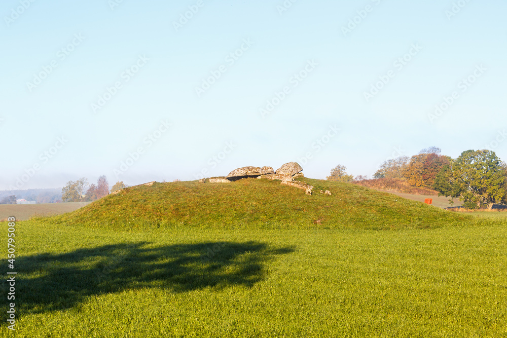 Fototapeta premium Megalith grave on a hill in a field
