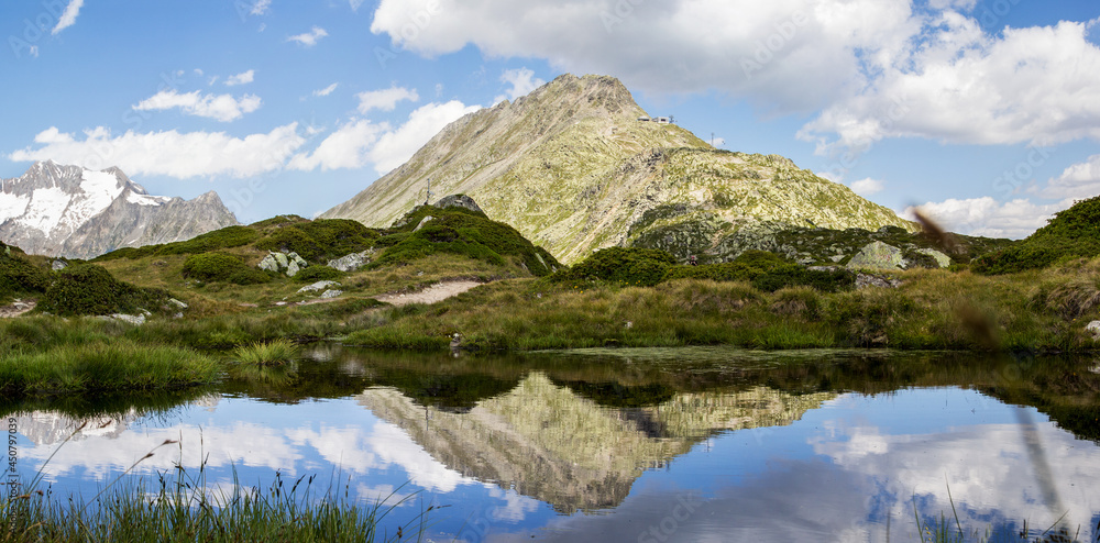 Reflection of Bettmerhorn peak on a mountain pond in the Aletsch Glacier hiking trail