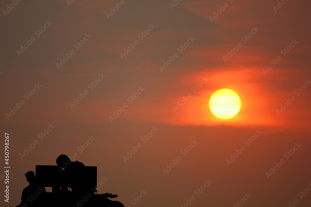 solider stand by militaly machine gun with sun set beauty sky abstract nature background