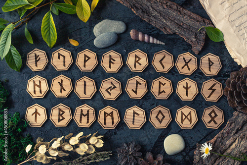 Wooden runes are lying on the table among various objects. Astrology and esotericism. Senior Futhark photo