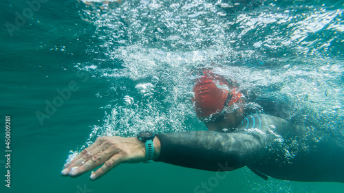 Athlete in a wetsuit swims in open water photo