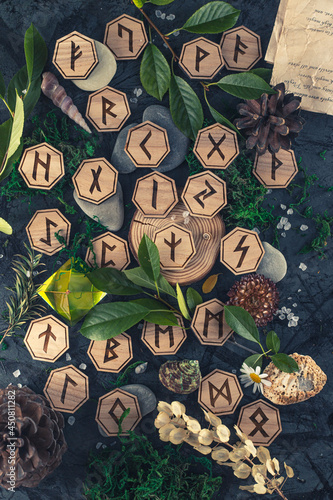 Wooden runes are lying on the table among various objects. Astrology and esotericism. Senior Futhark