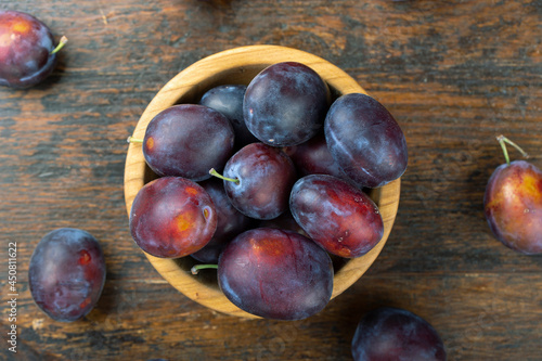Fresh plums in a wooden bowl. Harvesting.