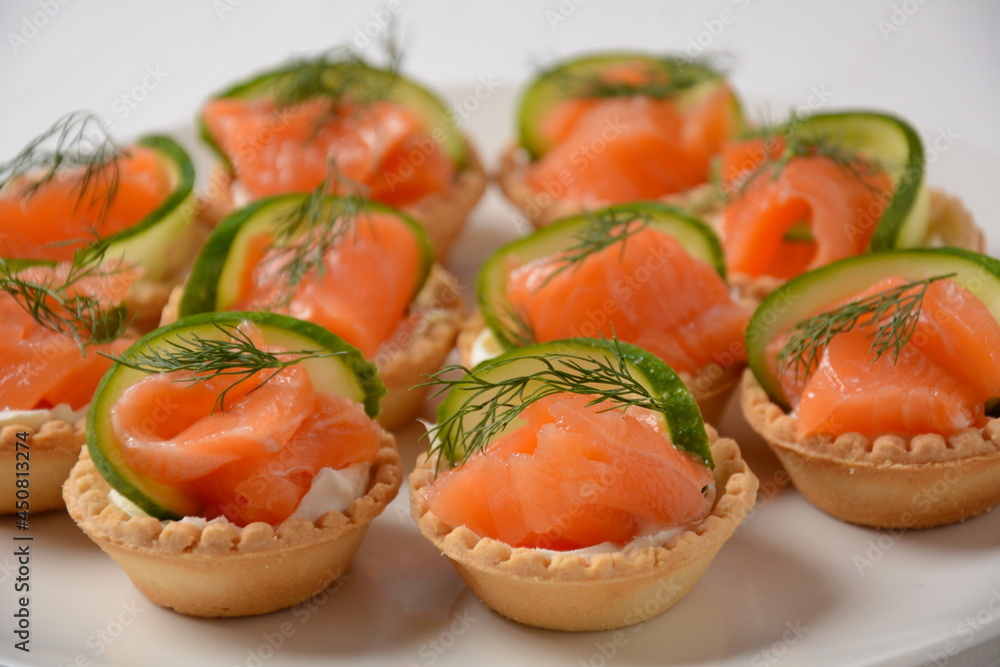 Tartlets with salmon, cheese, cucumber and dill. Tasty snacks with salted salmon and cottage cheese filling