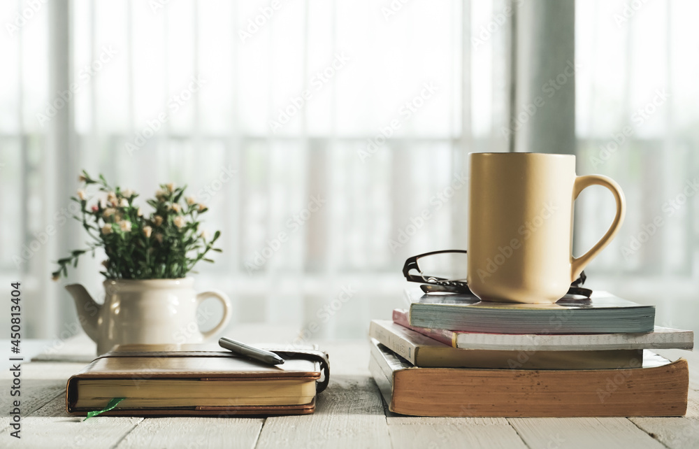Coffee cup, note book, a pen and a book on wood table in online learning at home concept. Coffee cup, note book, a pen and a book on wood table in online learning at home concept.