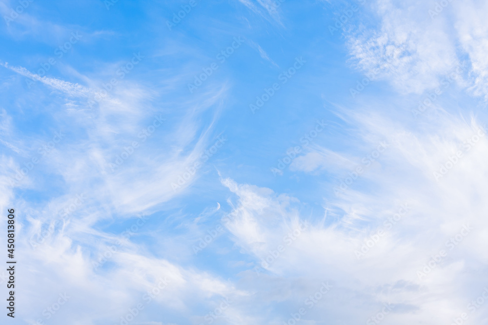 White cirrus clouds on a blue sky background White cirrus clouds on a blue sky background