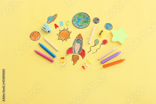 Back to school concept. Top view image of space ship, planets and student stationery over pastel yellow background
