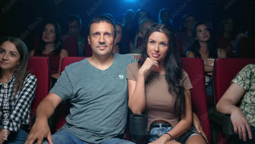 Hispanic couple watching film hugging romantic date at cinema feeling love and tenderness Hispanic couple watching film hugging romantic date at cinema feeling love and tenderness