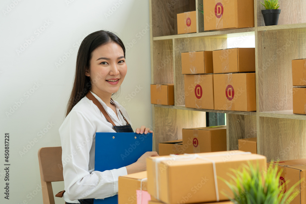 Startup small business entrepreneur SME, young asian woman working with laptop computer and delivery packaging box, online market packing, SME e-commerce seller concept. Startup small business entrepreneur SME, young asian woman working with laptop computer and delivery packaging box, online market packing, SME e-commerce seller concept.